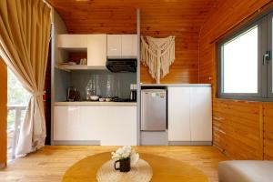 a kitchen with a refrigerator and a table in a room at Sim Forest Resort in Phú Quốc