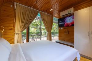 a bedroom with a bed and a large window at Sim Forest Resort in Phú Quốc