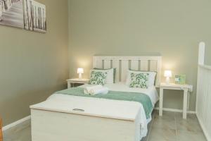 a bedroom with a white bed with two night stands at Accommodation on 3329 - Unit 2 in Gqeberha