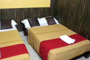 two beds in a hotel room with two bedsvisor at GSR RESIDENCy in Kanchipuram