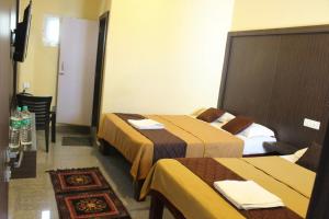 a hotel room with two beds and a table at GSR RESIDENCy in Kanchipuram