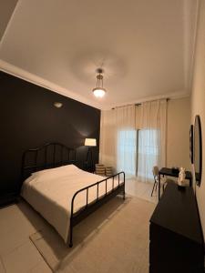 a bedroom with a bed and a black wall at Private rooms in Sharjah