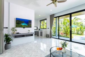 a living room with white walls and a ceiling fan at Nanuea Village Ao Nang in Ao Nang Beach