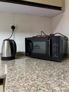 a microwave sitting on a counter in a kitchen at Private rooms in Sharjah