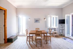a dining room with a wooden table and chairs at Blue Horizon Residence in Mitika