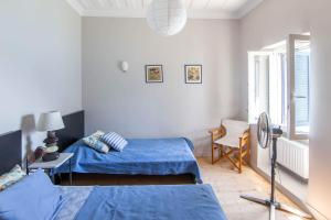 a bedroom with two beds and a desk with a fan at Blue Horizon Residence in Mitika