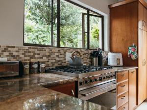 a kitchen with a stove with a tea kettle on it at Idube Guest House in Winterton +119 photos