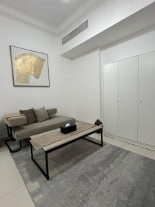 a living room with a couch and a coffee table at Private rooms in Sharjah