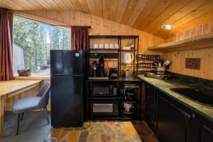 a kitchen with a black refrigerator and a sink at Riverside Loft Suite home in Leavenworth