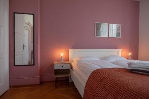 a bedroom with pink walls and a bed with a mirror at B&B Zoo Caffè & Ristorante in Zurich
