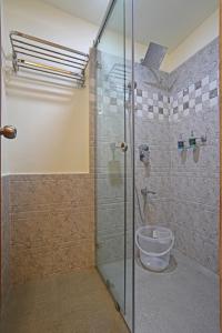 a bathroom with a glass shower with a toilet at Coffee Courtyard - Boutique Estate Retreat, Coorg in Kurchi