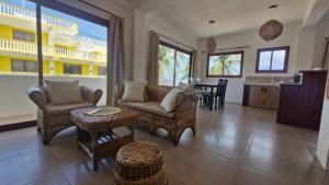 a living room with chairs and a table and a kitchen at yamba pacifico in San Isidro