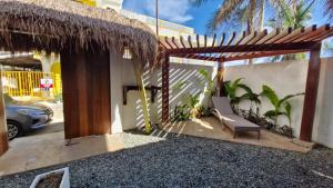 a patio with a chair and a thatch roof at yamba pacifico in San Isidro