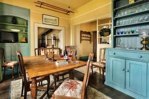 a dining room with a wooden table and blue cabinets at Finest Retreats - Bourne Edge in Morland +19 photos