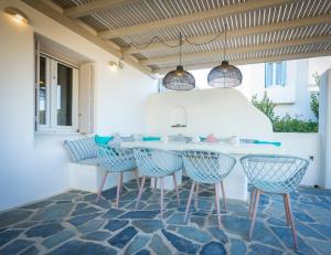 a dining room with blue chairs and a table at Villa Ione in Mikri Vigla