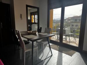 a dining room with a table and chairs and a balcony at Aldea Bricia 201 in Posada de Llanes