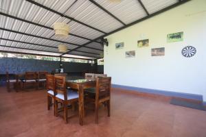 a dining room with a table and chairs at Coffee Courtyard - Boutique Estate Retreat, Coorg in Kurchi