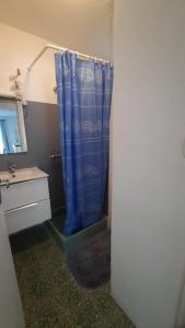 a bathroom with a shower with a blue shower curtain at T2Leucate La Franqui Calme Mer Clim Parking P in Leucate