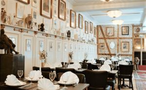 a dining room with tables and chairs and a wall with pictures at Hotel Allegade 10 in Copenhagen