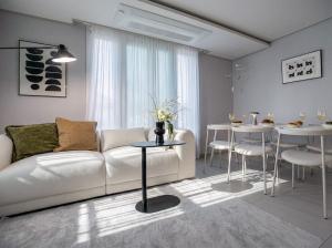 a living room with a white couch and a table at Seoul 3R,4B,2BA,All rooms AC, 지하철도보5분, 동대문15분, 명동25분, 이태원,성수,서울역 30분 in Seoul