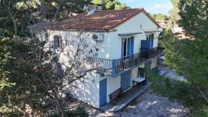 a white house with blue doors and a balcony at T2Leucate La Franqui Calme Mer Clim Parking P in Leucate +14 photos