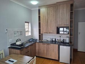 a kitchen with wooden cabinets and a wooden table at R & A's Cottage in Strand +10 photos