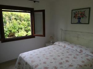 a bedroom with a bed and a window at Villa Lilly 2 in Punta Molara