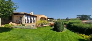 a house with a yard with green grass at Villa Lilly 2 in Punta Molara