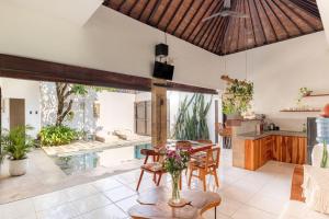 a living room with a table and a pool at Cozy villa 2bdr in Seminyak , pool,800m beach in Seminyak