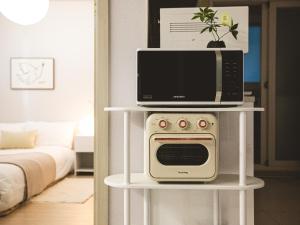 a microwave on top of a white table in a living room at Seoul 3R,4B,2BA,All rooms AC, 지하철도보5분, 동대문15분, 명동25분, 이태원,성수,서울역 30분 in Seoul