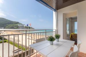a balcony with a table and a view of the beach at Bakio Beach in Bakio