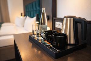 a tray with coffee cups and a bottle on a table at Hotel Hamburg Nord in Norderstedt