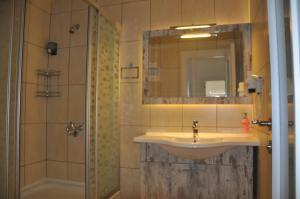 a bathroom with a sink and a shower with a mirror at Nur Hotel in Kaş