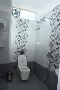 a bathroom with a toilet and a shower and a sink at Sea Shore In in Port Blair +33 photos