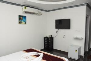 a room with a bed and a tv on the wall at Sea Shore In in Port Blair