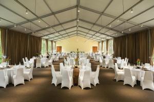 a large banquet hall with white tables and white chairs at Homm Laguna Bintan in Lagoi +78 photos