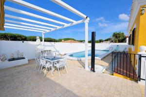 a patio with a table and chairs and a swimming pool at Casa oasis de chiclana in Novo Sancti Petri