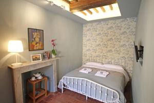 a small bedroom with a bed and a fireplace at La Casa sulla Piazza in Cortona