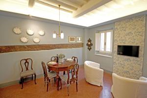 a dining room with a table and chairs and a tv at La Casa sulla Piazza in Cortona