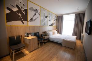 a bedroom with a bed and a desk and a chair at Arena Sport Hotel in Quba