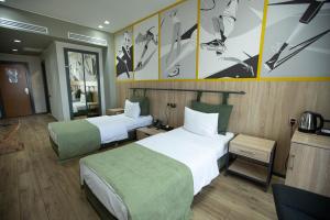a hotel room with two beds with green and white sheets at Arena Sport Hotel in Quba +43 photos