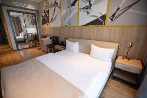 a bedroom with a large white bed and a living room at Arena Sport Hotel in Quba