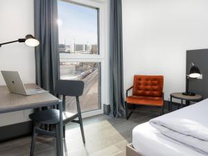 a hotel room with a bed and a desk and a window at smartments Frankfurt City-Ost in Frankfurt