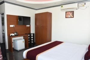 a bedroom with a bed and a cabinet and a tv at Sea Shore In in Port Blair