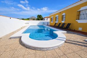 a swimming pool on a patio next to a building at Casa oasis de chiclana in Novo Sancti Petri