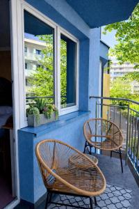 a balcony with two chairs and a window at Apartamenty Port 111 in Kołobrzeg