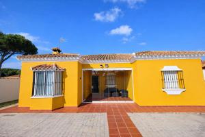 a yellow house with a red tile roof at Casa oasis de chiclana in Novo Sancti Petri +14 photos