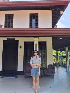 a woman standing in front of a house at VILLA GREEN VILLAGE in Kamburugamuwa