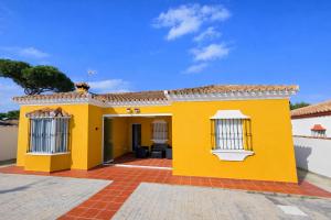 a yellow house with a red brick courtyard at Casa oasis de chiclana in Novo Sancti Petri
