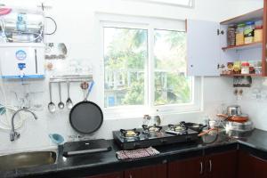 a kitchen with a stove and a window at Sea Shore In in Port Blair